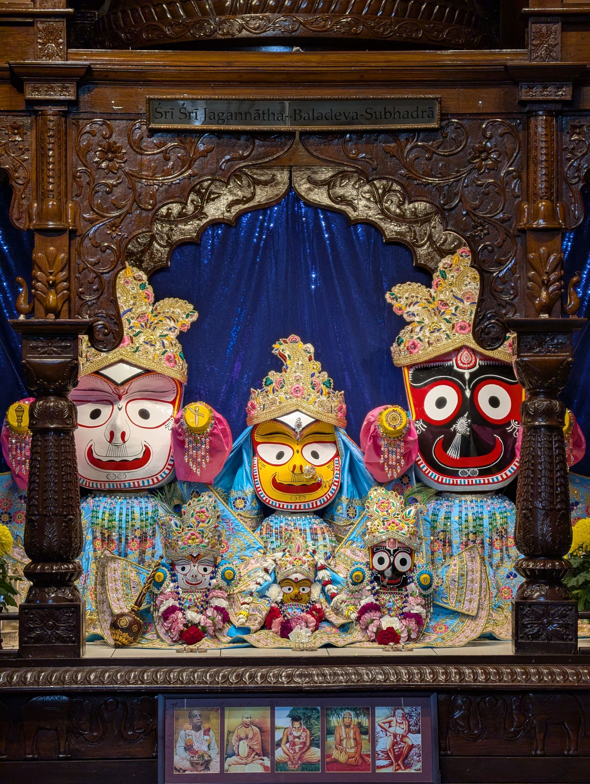 Colorful Jagannath deity figures adorned with flowers and textiles, Toronto temple.