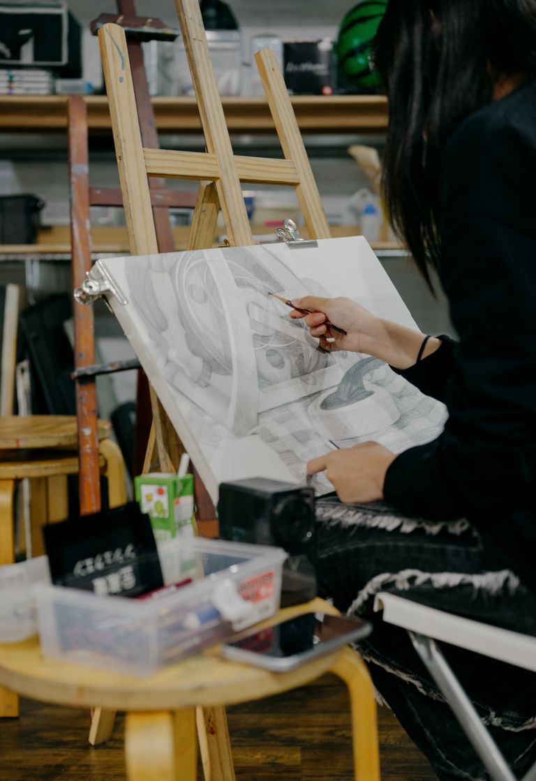 An artist sketching at an easel in a Tokyo art studio, showcasing creativity.