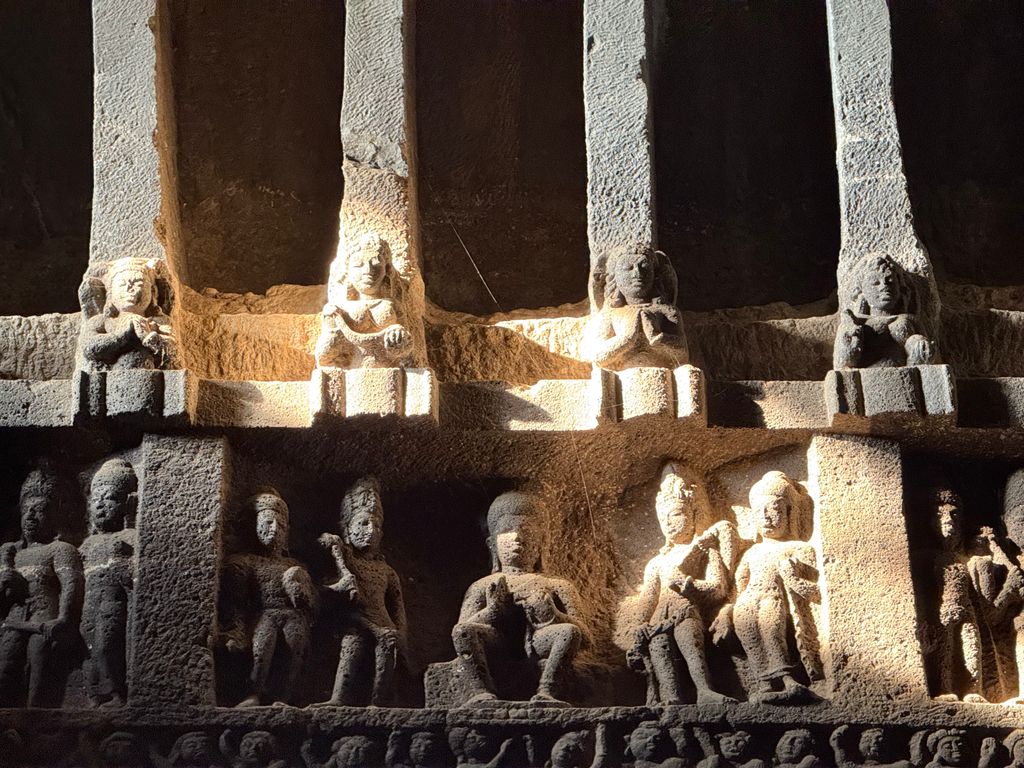 Detailed view of ancient rock-cut sculptures in an Indian cave, showcasing historical artistry.