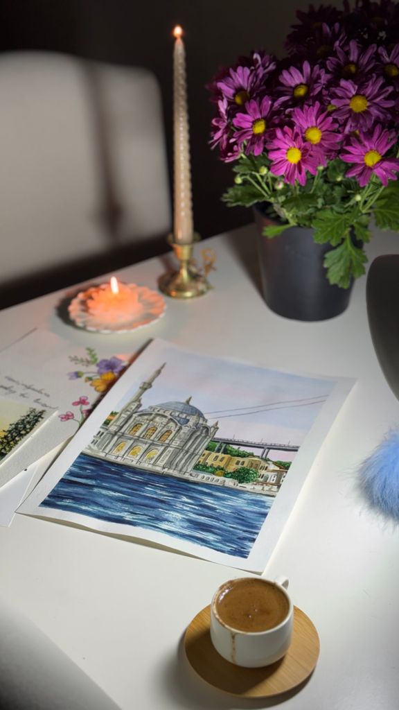 Serene still life with flowers, art, and coffee on a table.