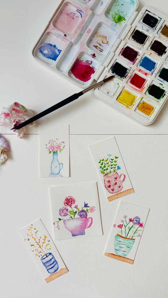 Vibrant watercolor painting of floral designs with paint palette, perfect for art enthusiasts.